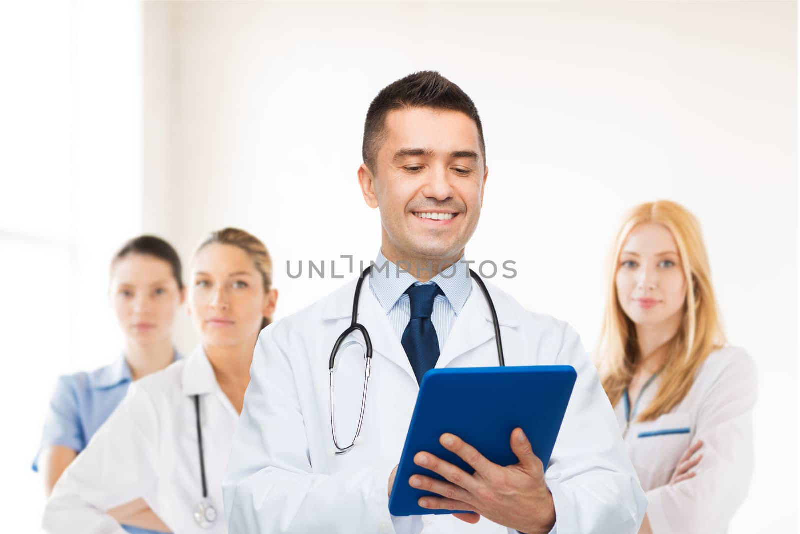 smiling male doctor with tablet pc at hospital by dolgachov