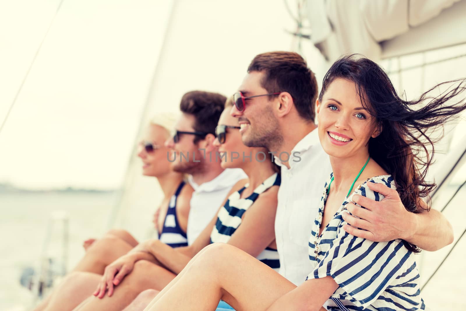 vacation, travel, sea, friendship and people concept - smiling friends sitting on yacht deck