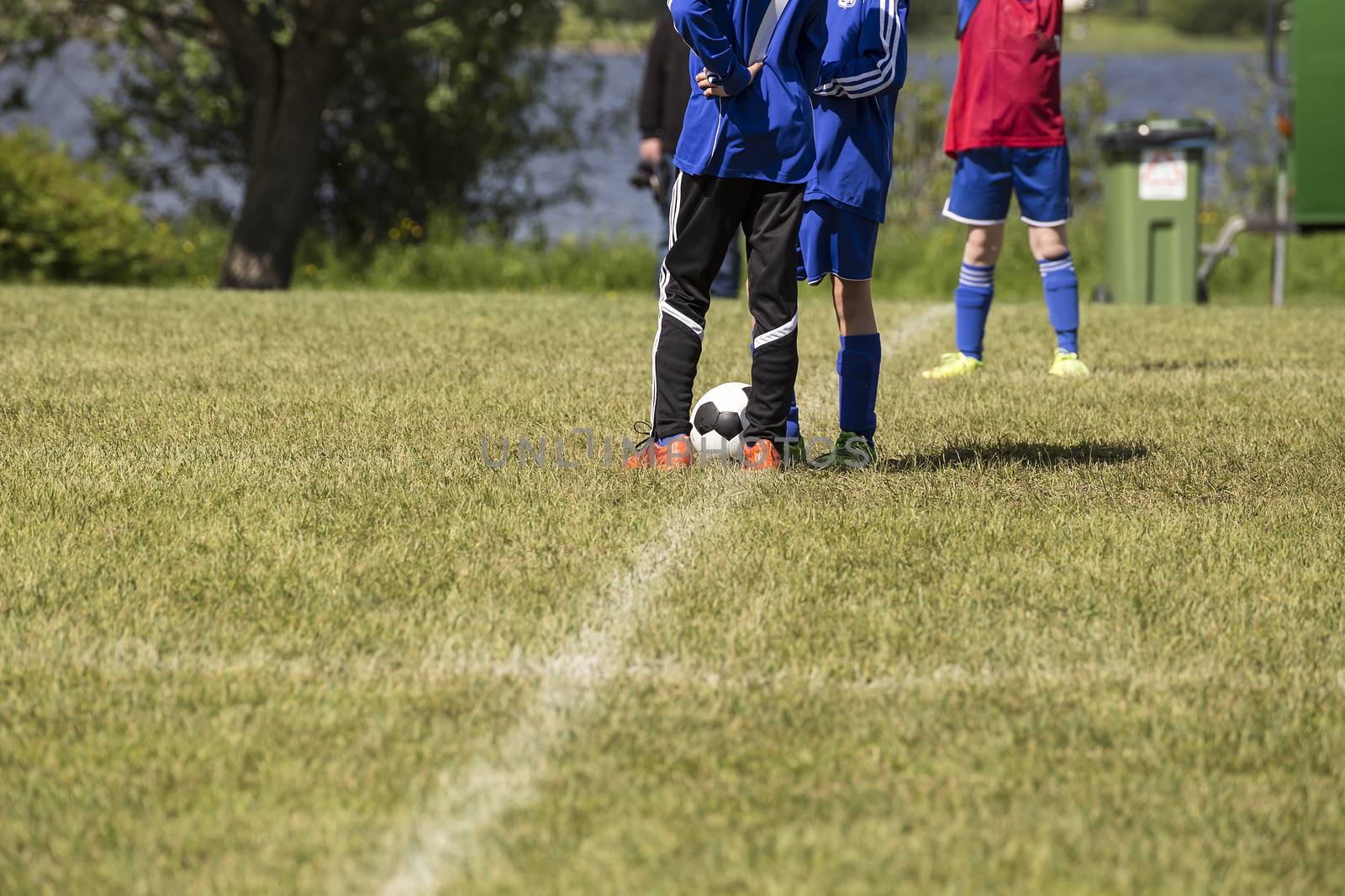 Three soccer players waiting for the referee to start the game.