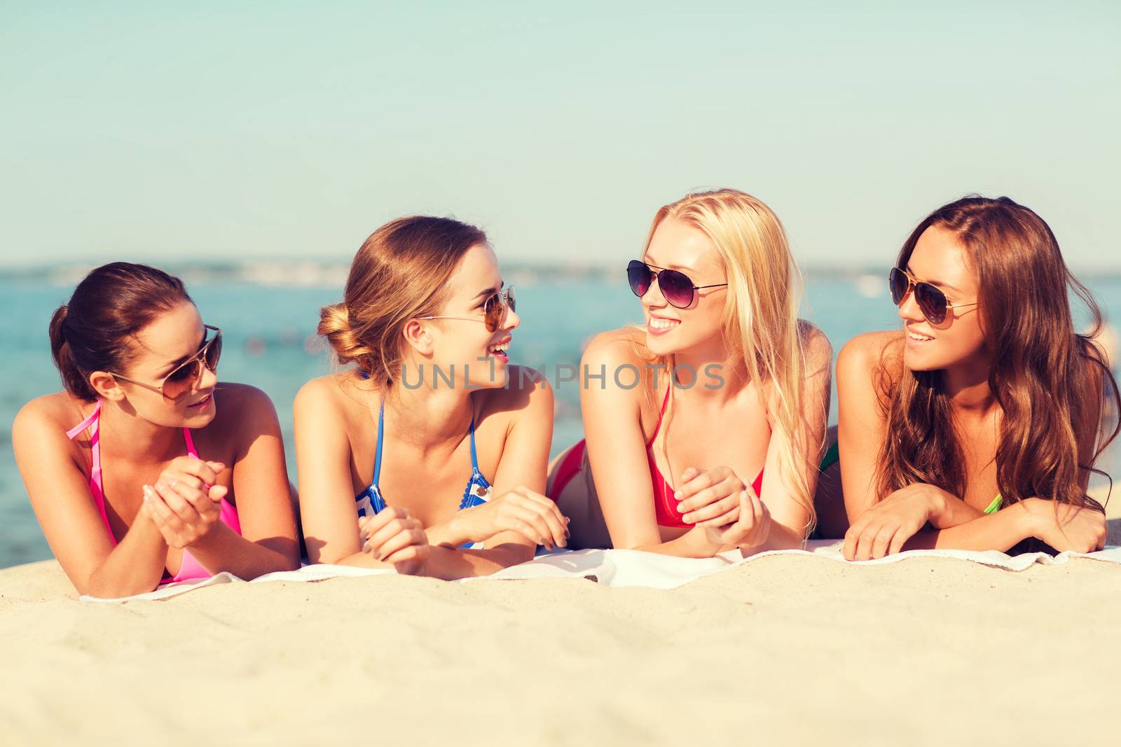 group of smiling women in sunglasses on beach by dolgachov
