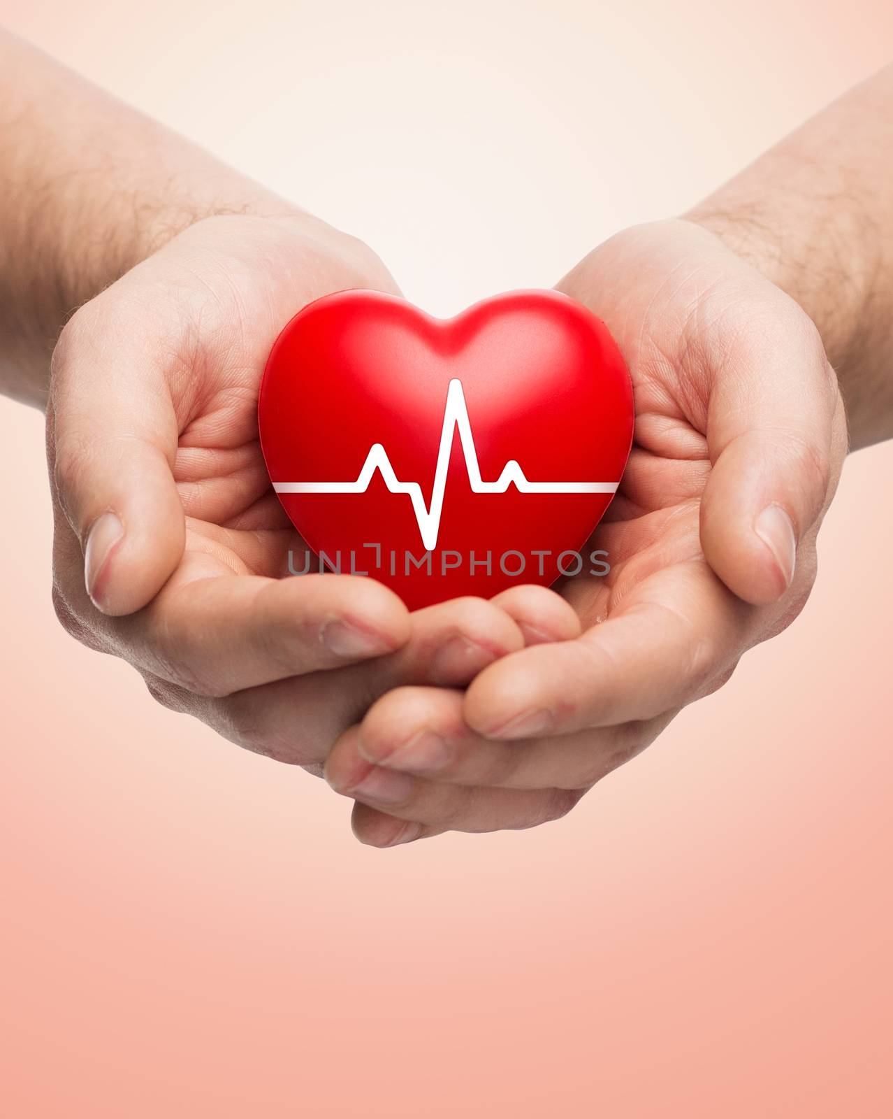 family health, charity and medicine concept - close up of hands holding red heart with cardiogram over beige background