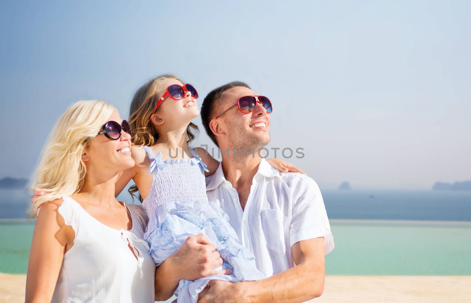 holidays, travel, tourism and people concept - happy family over summer beach background