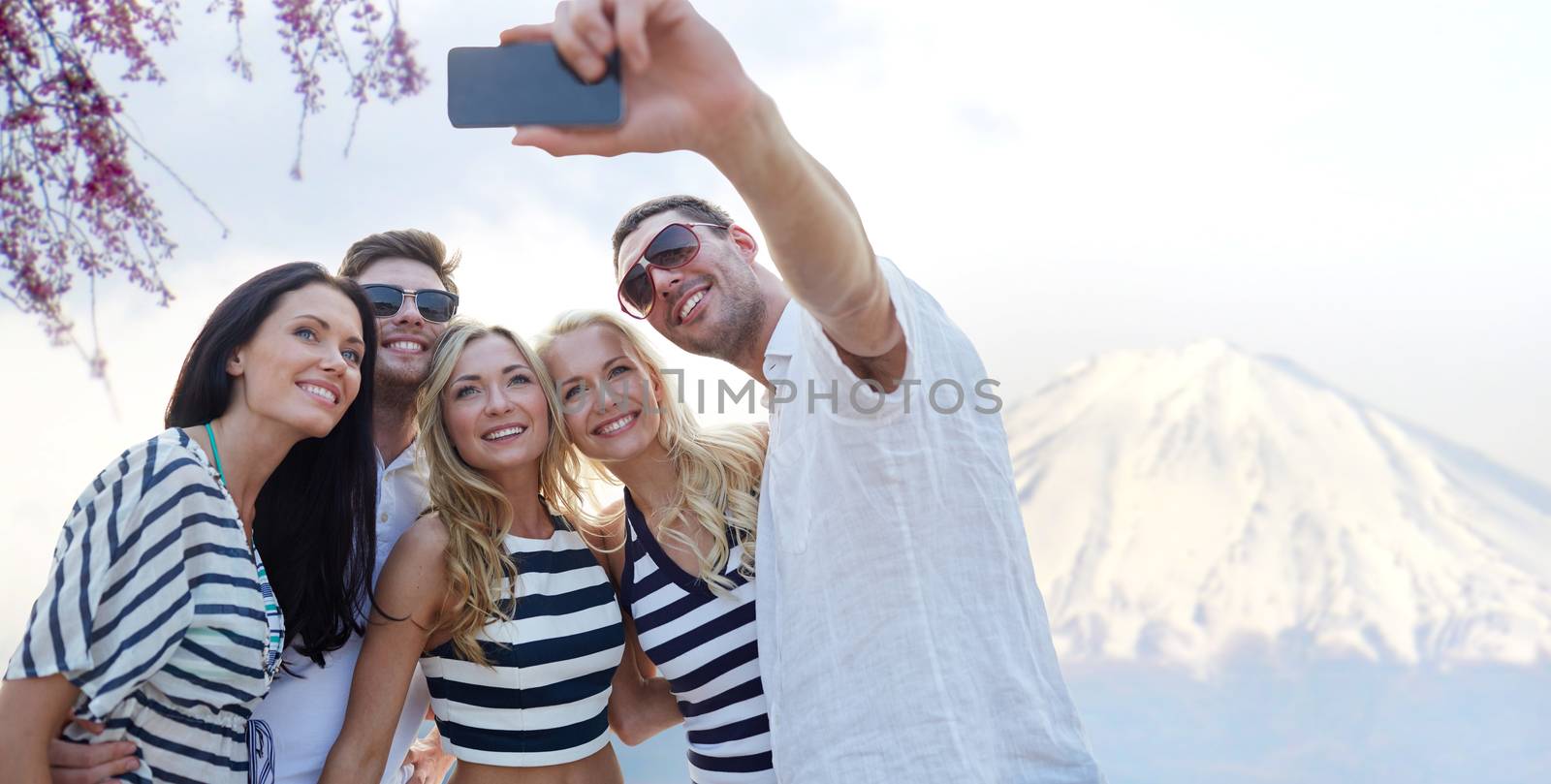 summer, asia, tourism, technology and people concept - group of smiling friends taking selfie with smartphone over fudjiyama mountain background