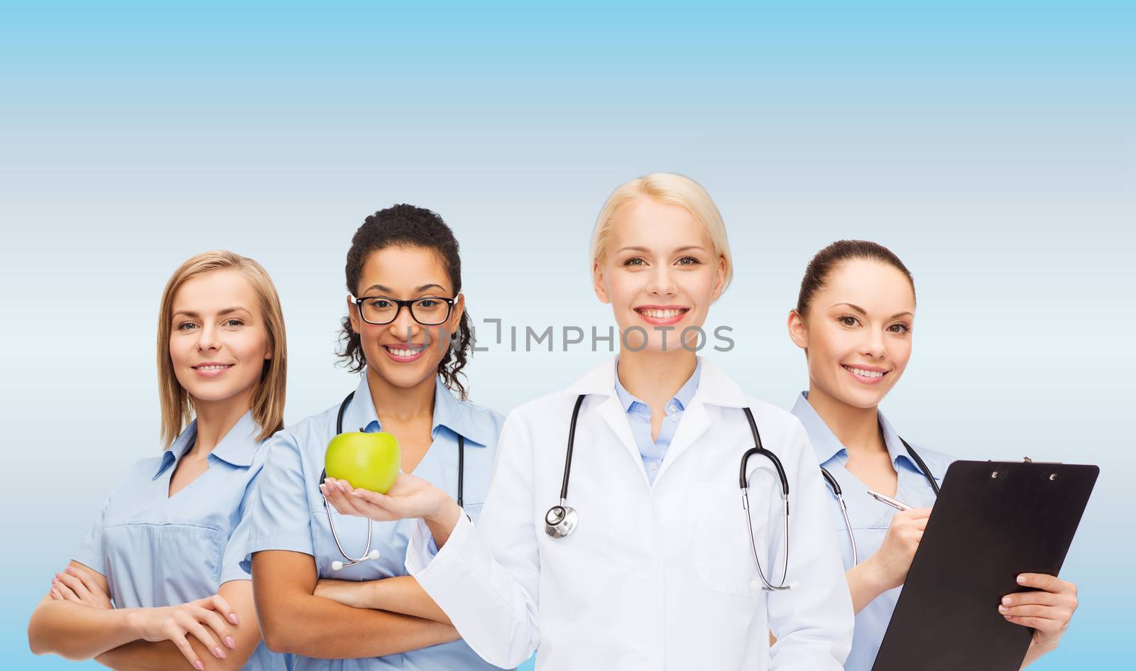 healthcare and medicine concept - smiling female doctor and nurses with green apple
