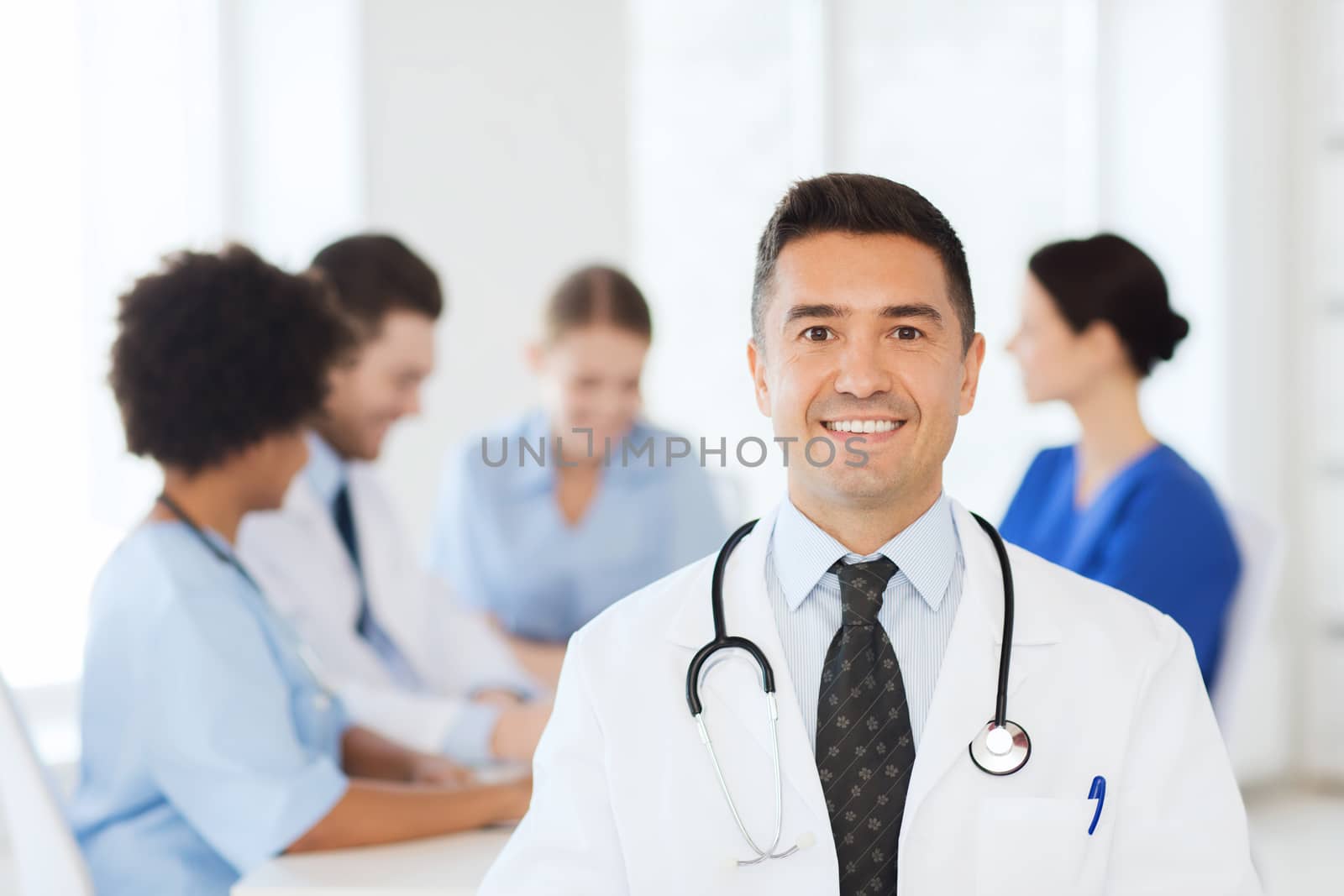 happy doctor over group of medics at hospital by dolgachov