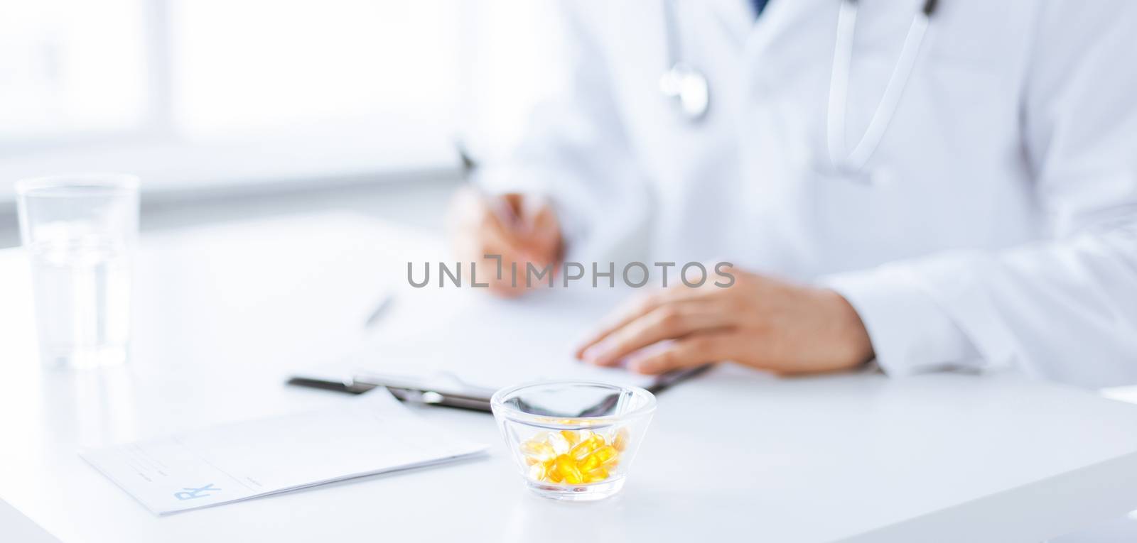 close up of male doctor writing prescription paper and capsules