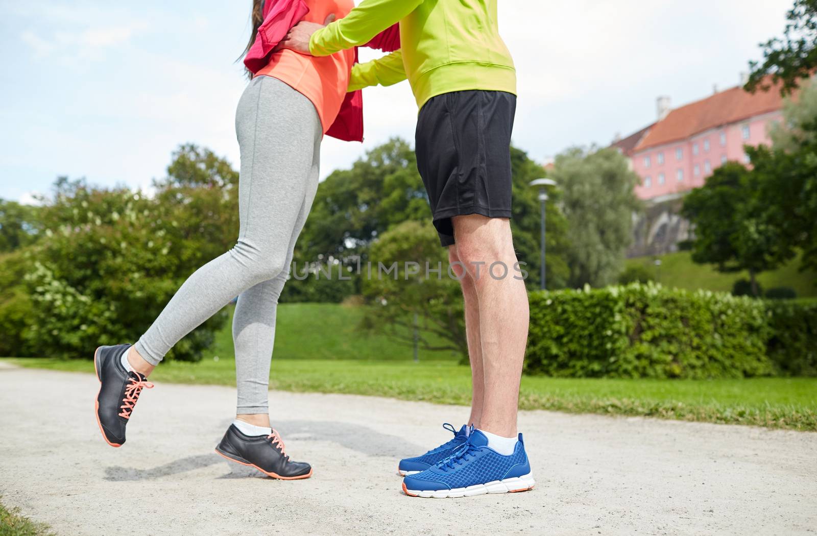 close up of couple in sportswear outdoors by dolgachov