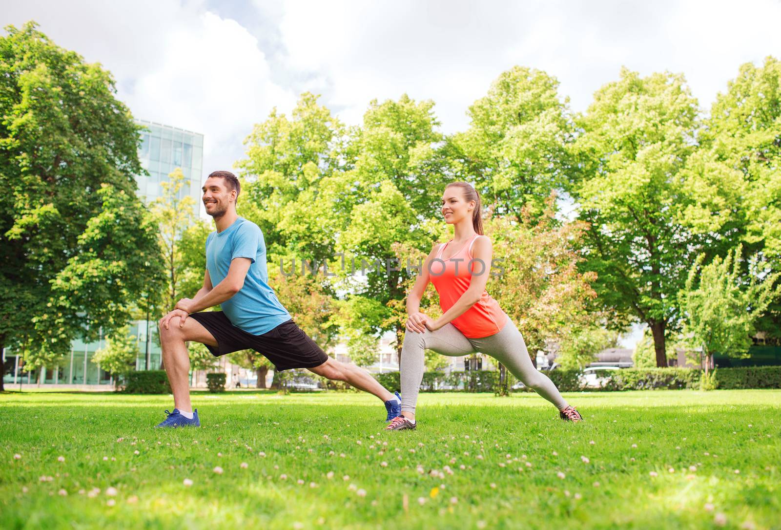 smiling couple stretching outdoors by dolgachov