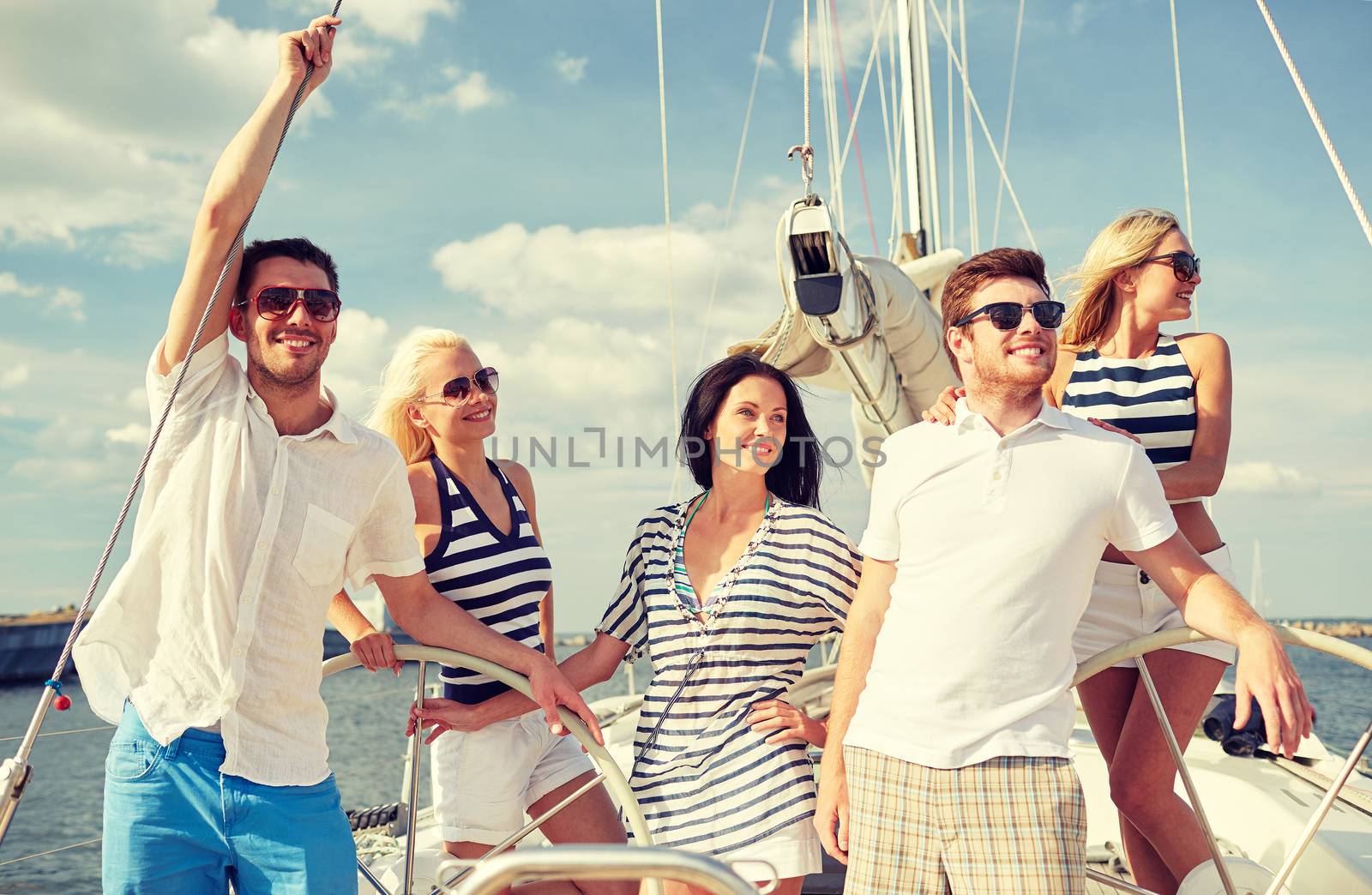 smiling friends sailing on yacht by dolgachov