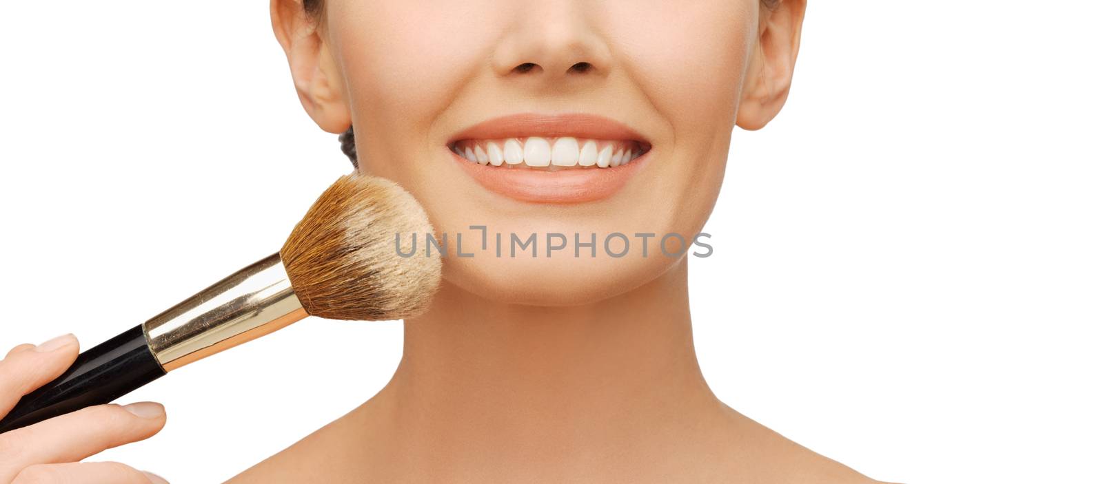 beauty and makeup concept - woman applying powder foundation with brush