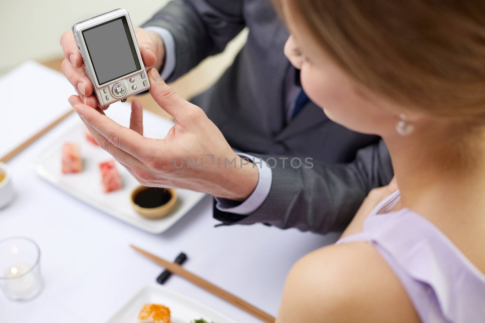 close up of couple with camera at restaurant by dolgachov