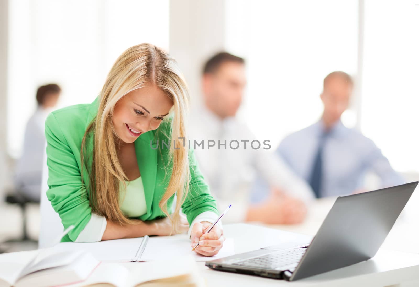 attractive businesswoman taking notes in office by dolgachov