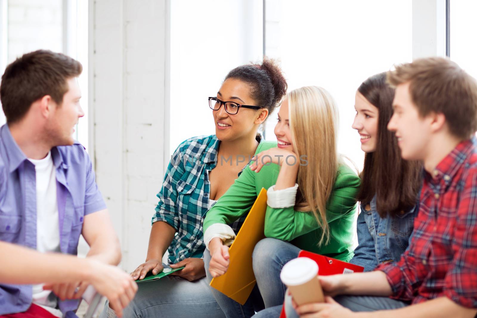 students communicating and laughing at school by dolgachov