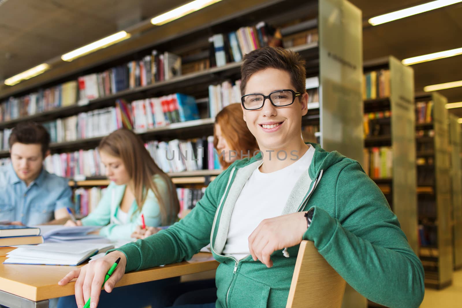 happy student boy reading books in library by dolgachov