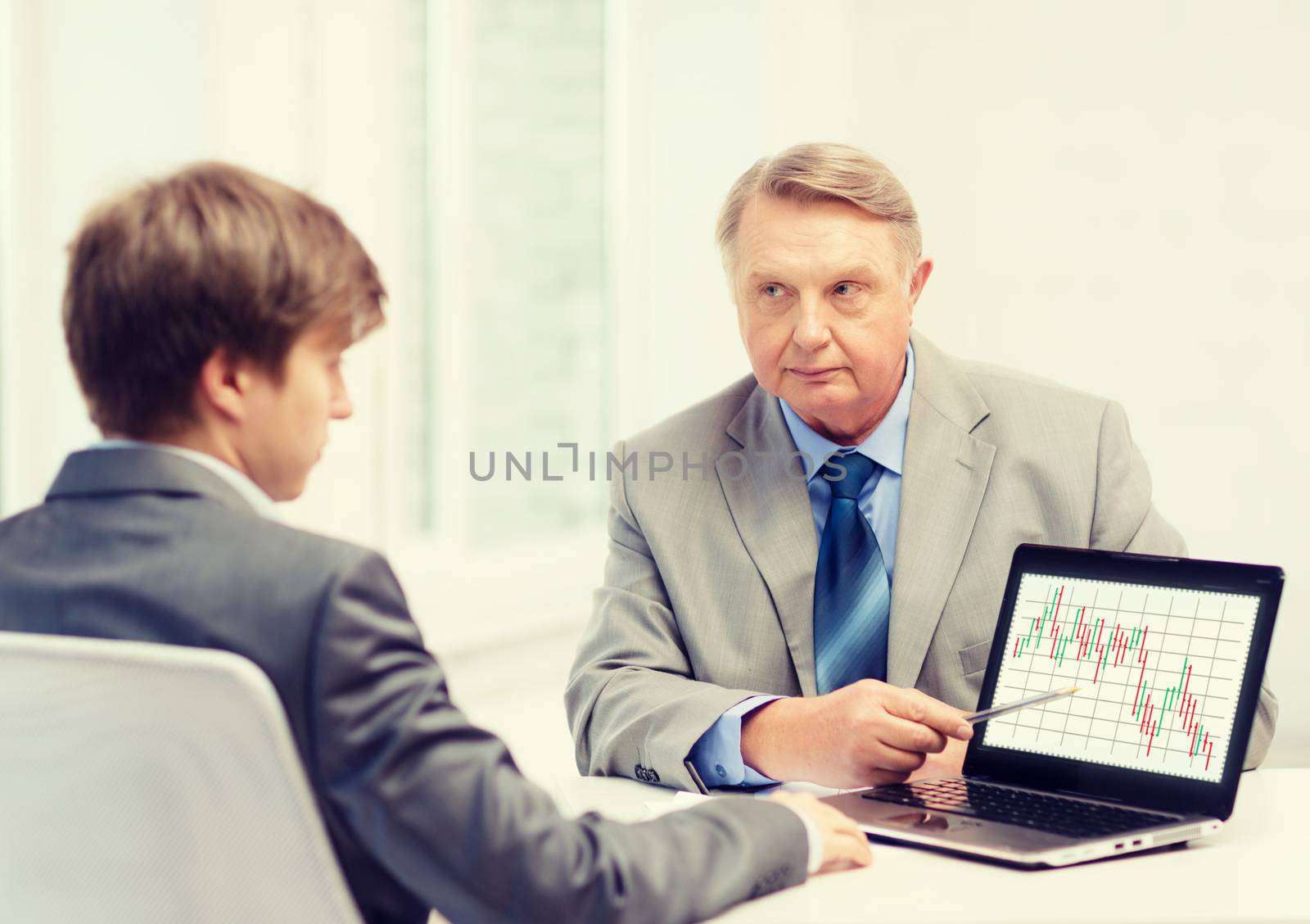 older man and young man with laptop computer by dolgachov