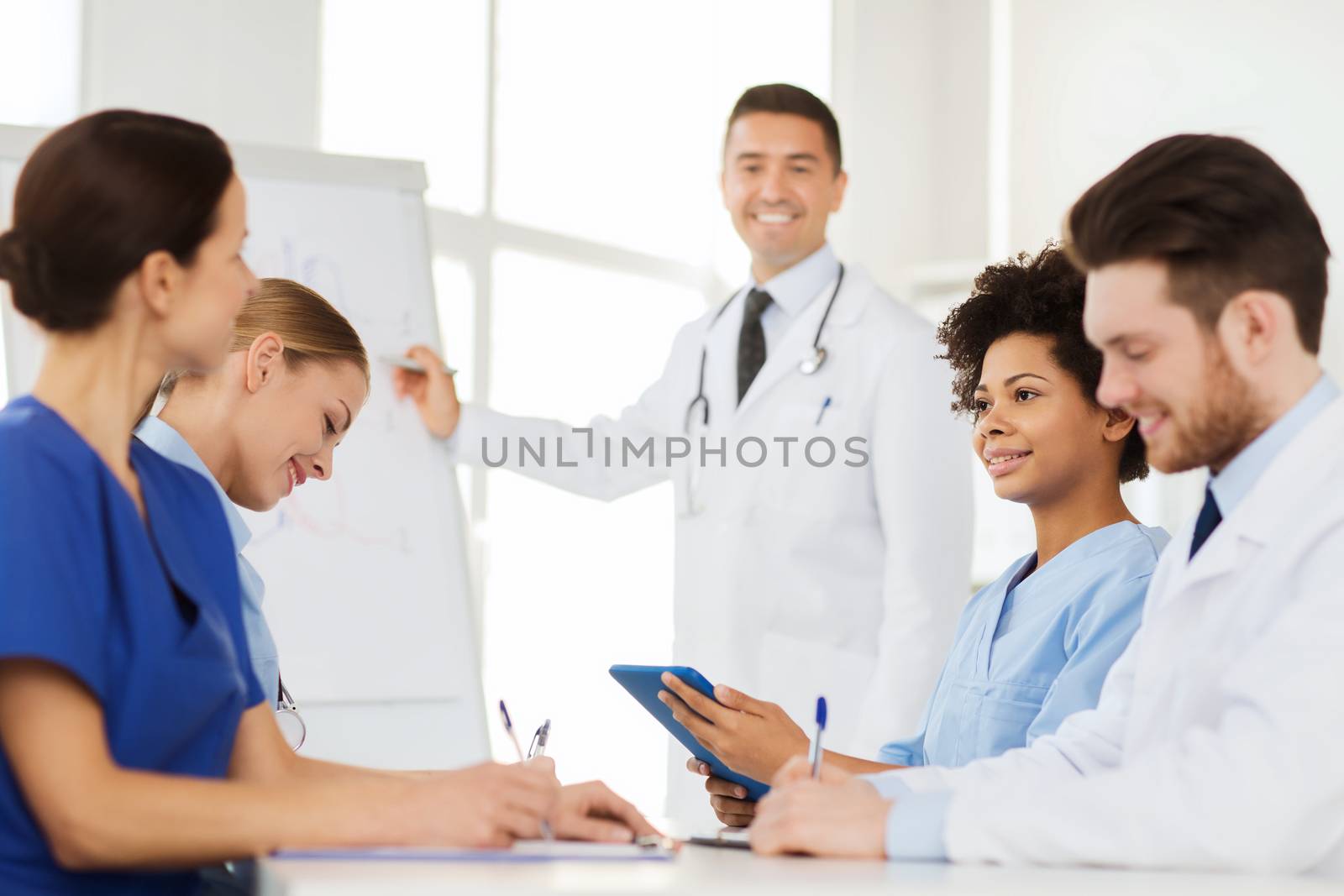 hospital, profession, medical education, people and medicine concept - group of happy doctors meeting on presentation at hospital