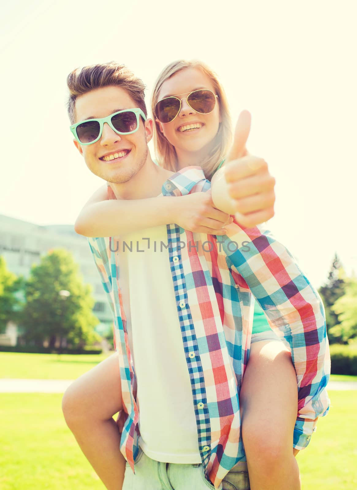 smiling couple having fun and showing thumbs up by dolgachov