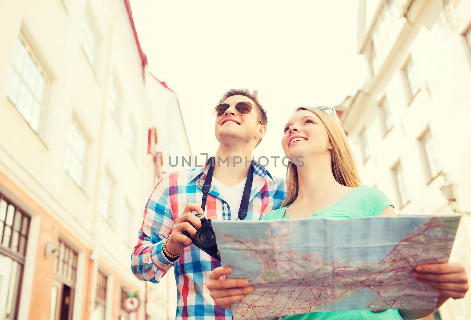 travel, vacation, technology and friendship concept - smiling couple with map and photo camera exploring city