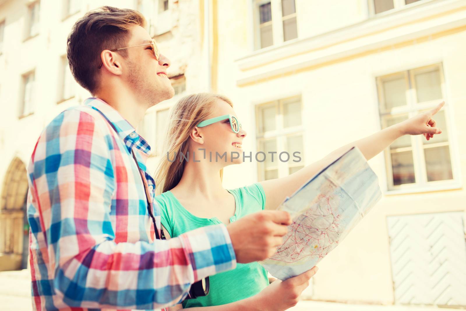 smiling couple with map and photo camera in city by dolgachov