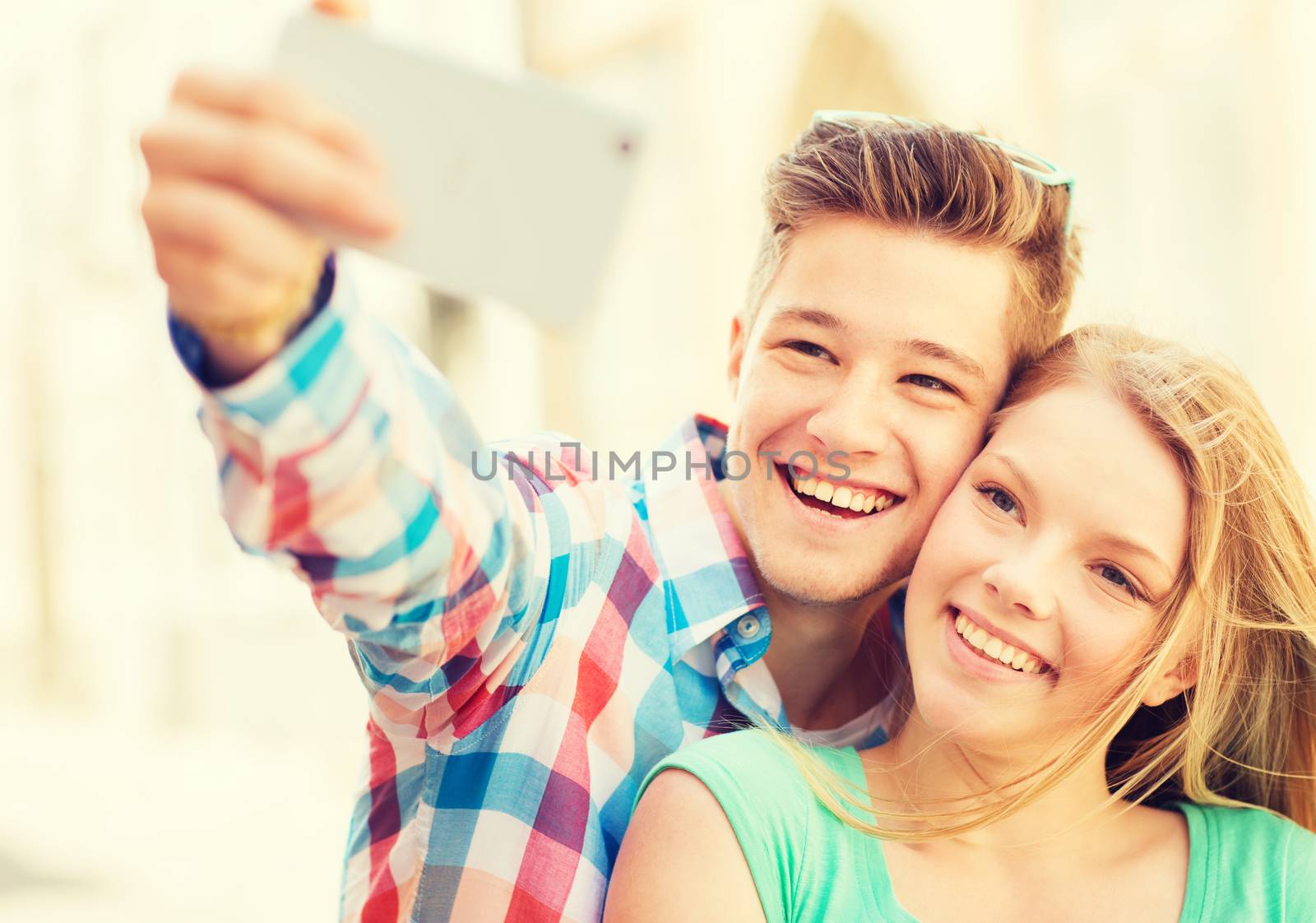 smiling couple with smartphone in city by dolgachov