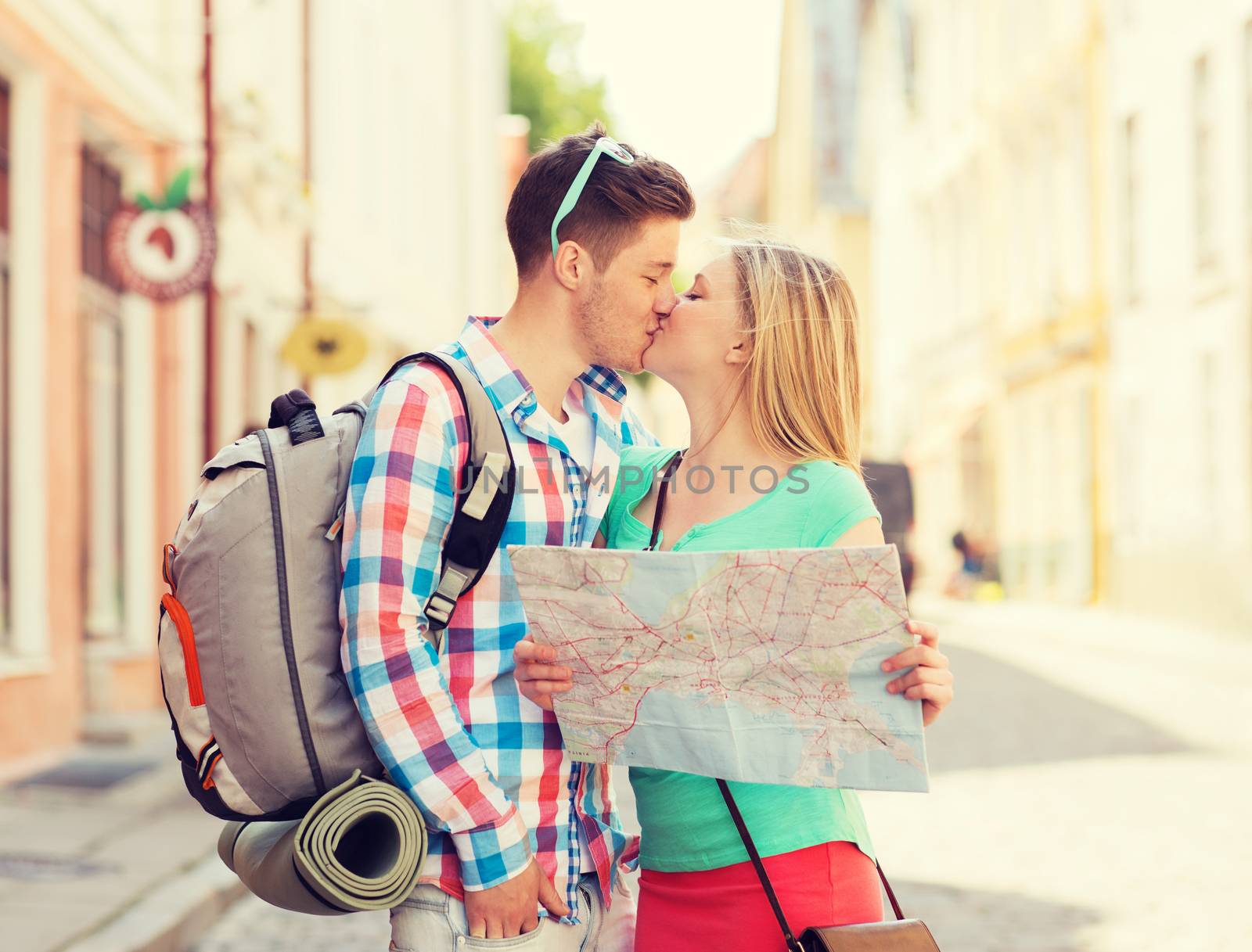 travel, vacation, love and friendship concept - smiling couple with map and backpack in city