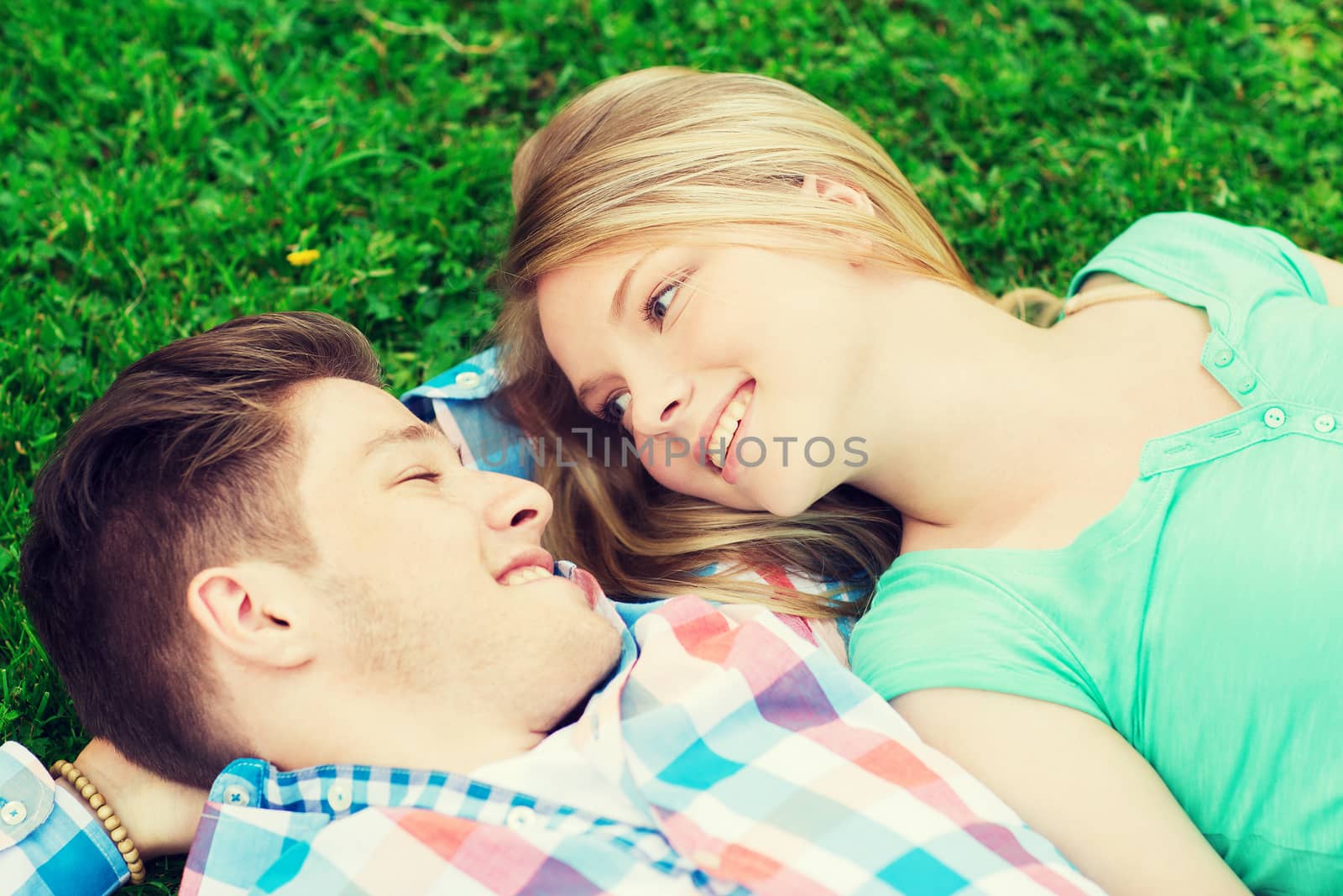 smiling couple lying on grass in park by dolgachov