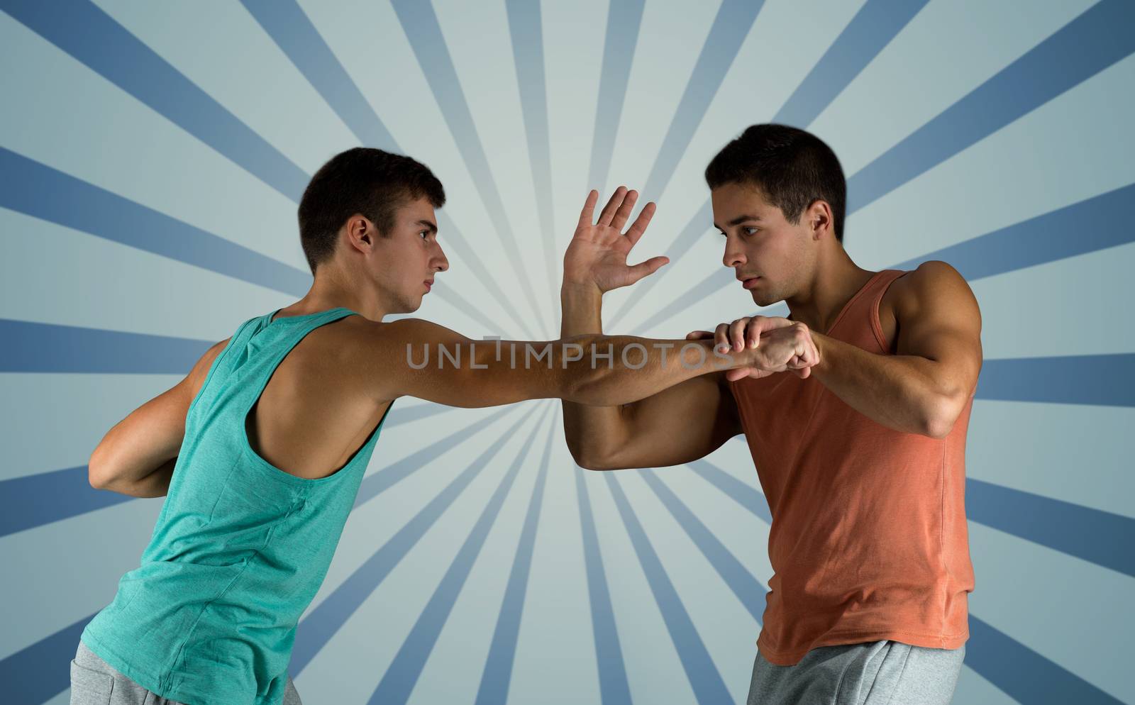 sport, competition, strength and people concept - young men fighting hand-to-hand over blue burst rays background