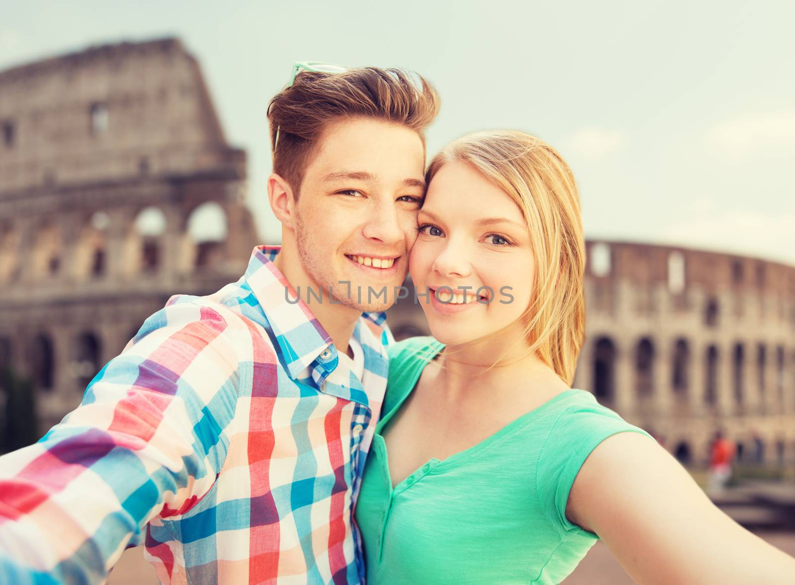 smiling couple taking selfie over coliseum by dolgachov