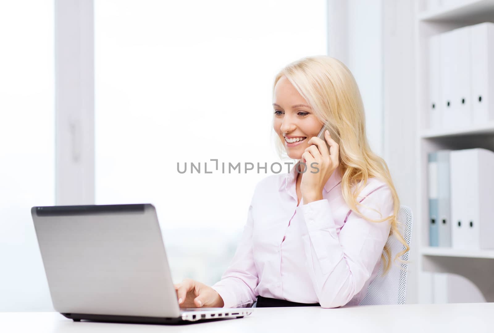 smiling businesswoman calling on smartphone by dolgachov