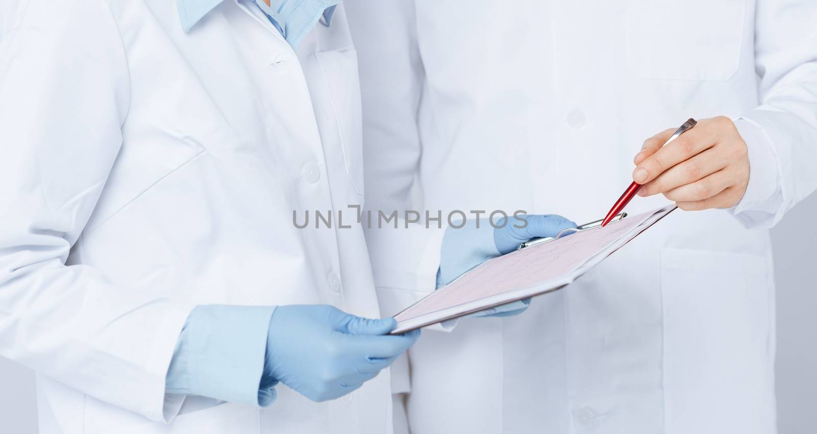 nurse and male doctor holding cardiogram by dolgachov