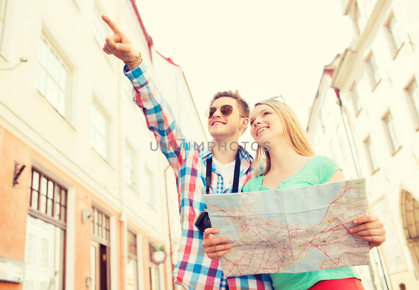 smiling couple with map and photo camera in city by dolgachov