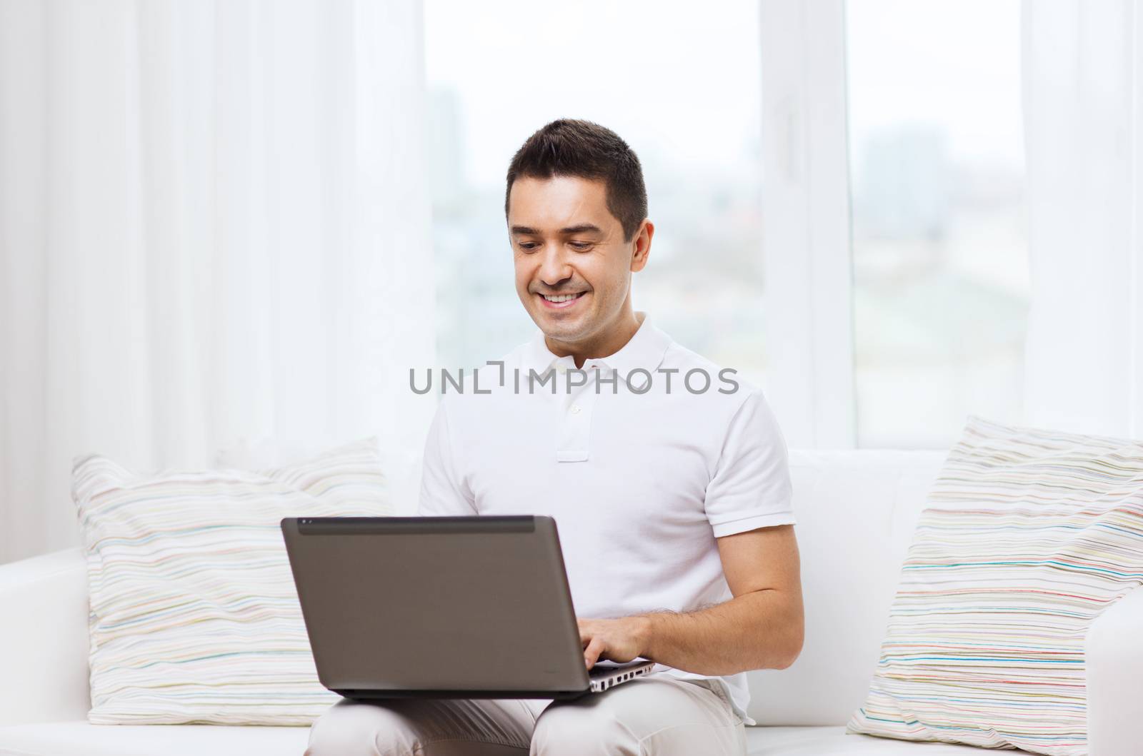 technology, people lifestyle and networking concept - happy man working with laptop computer at home