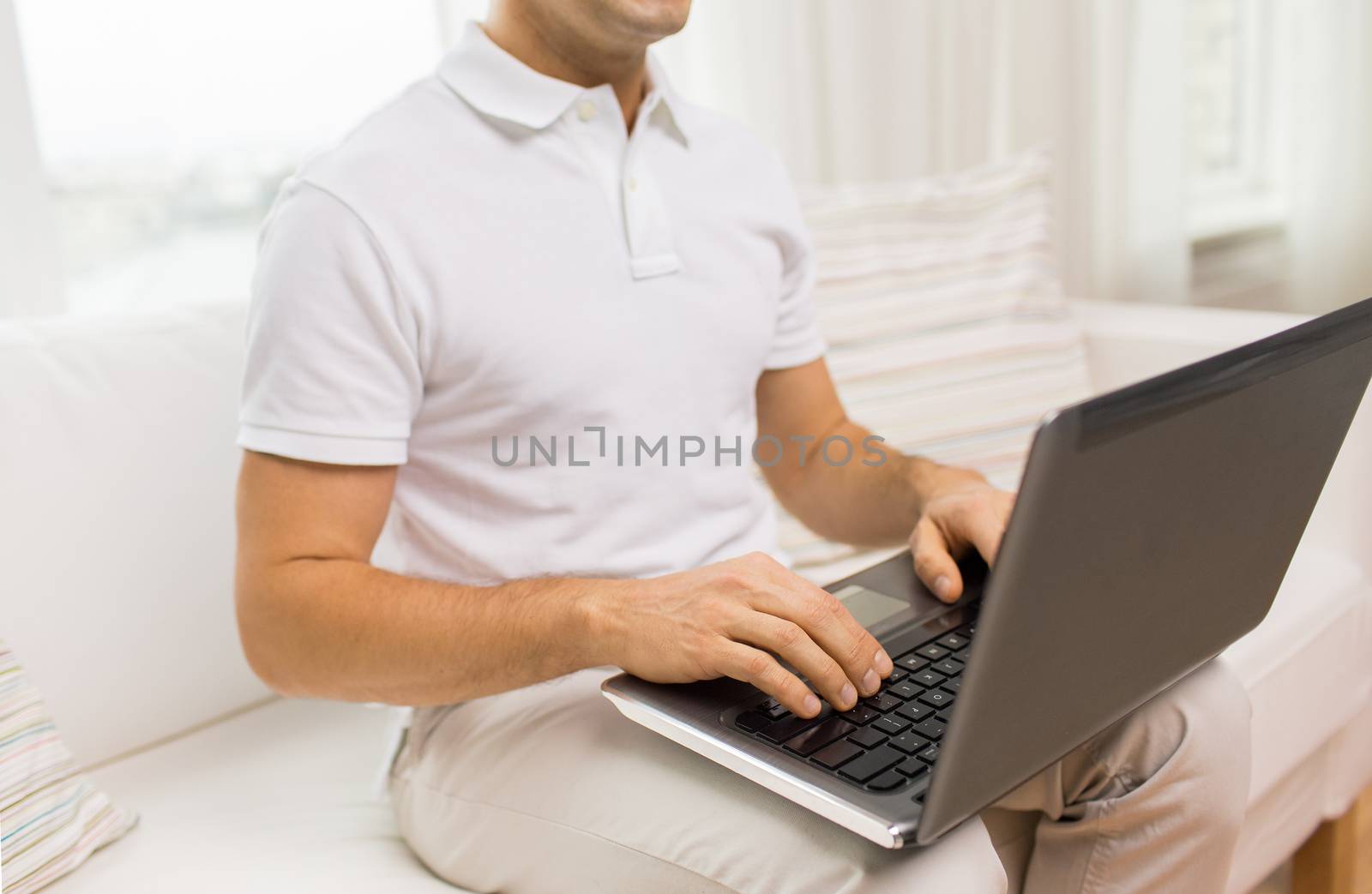 technology, people lifestyle and networking concept - close up of man working with laptop computer at home