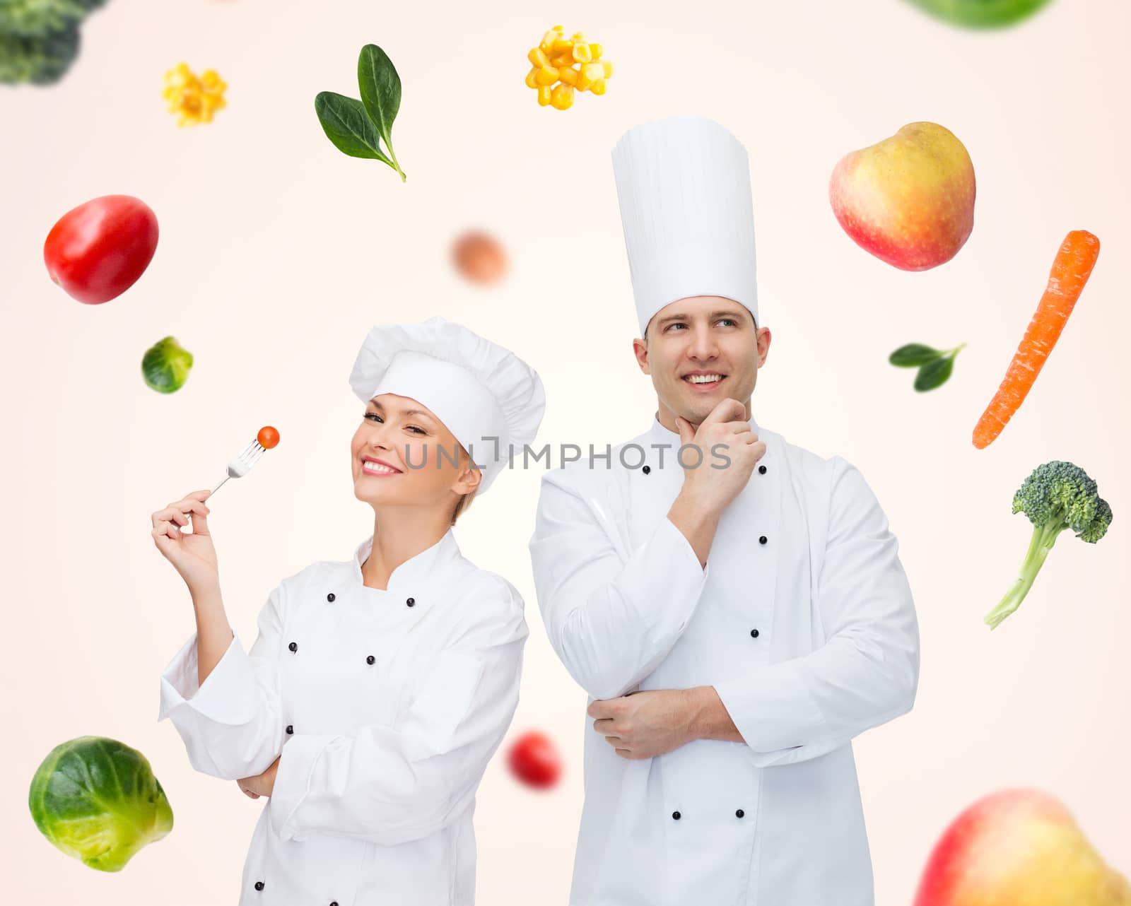 cooking, profession, inspiration, vegetarian diet and people concept - happy chef couple or cooks eating and thinking over beige background with falling vegetables
