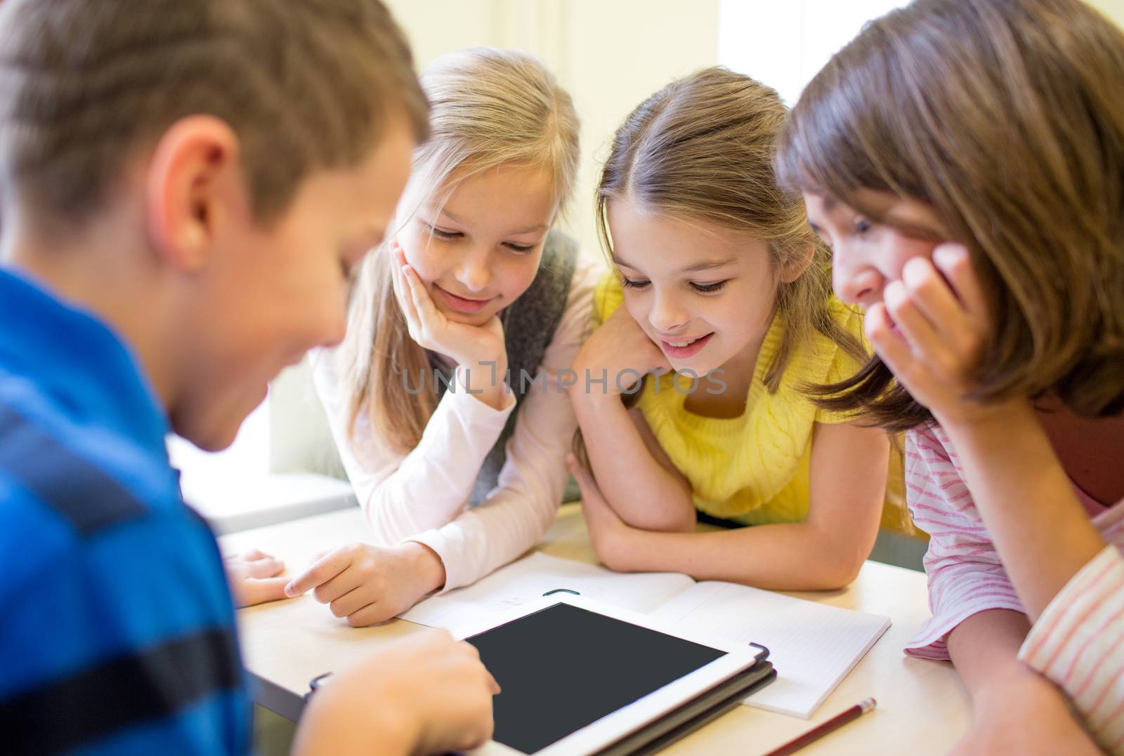 education, elementary school, learning, technology and people concept - group of school kids with tablet pc computer having fun on break in classroom