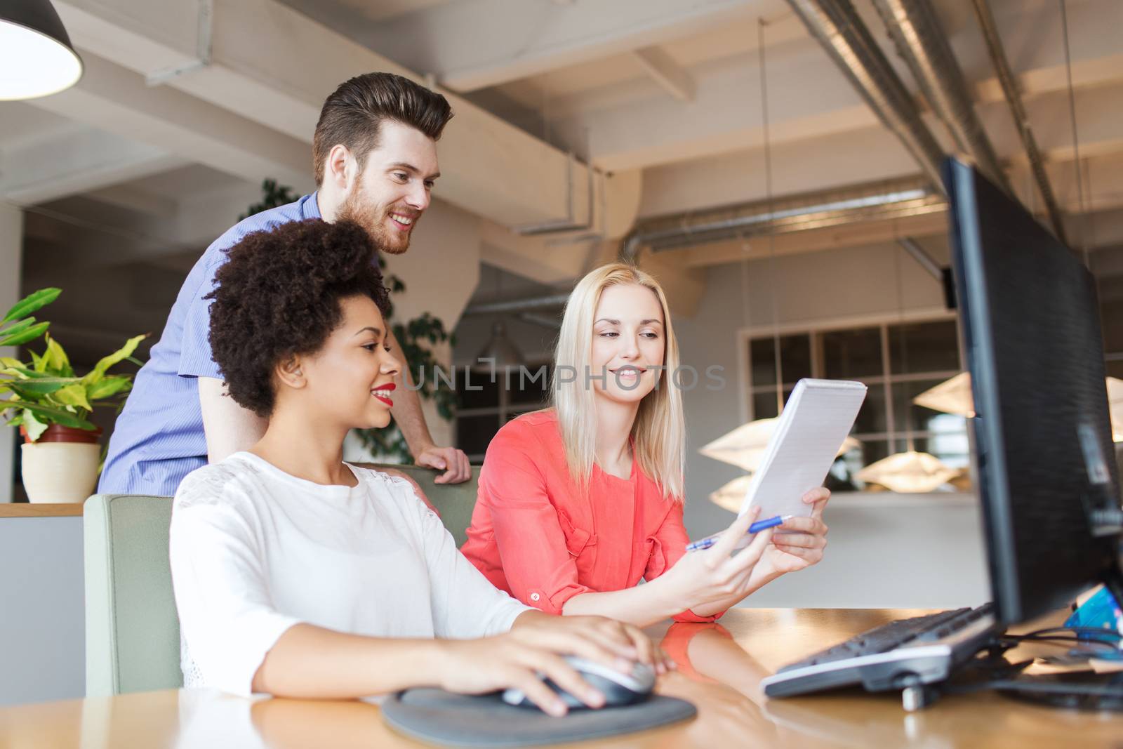 business, startup and people concept - happy creative team with computer and notebook in office