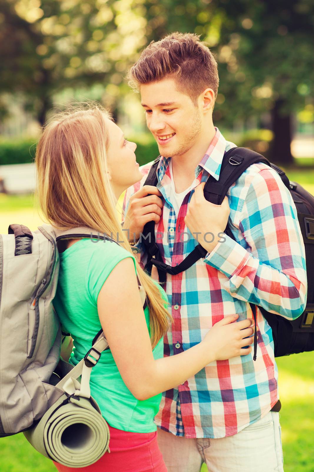 travel, vacation, tourism and friendship concept - smiling couple with backpacks in nature