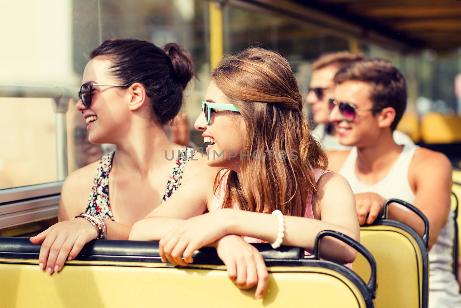 friendship, travel, vacation, summer and people concept - group of smiling friends traveling by tour bus