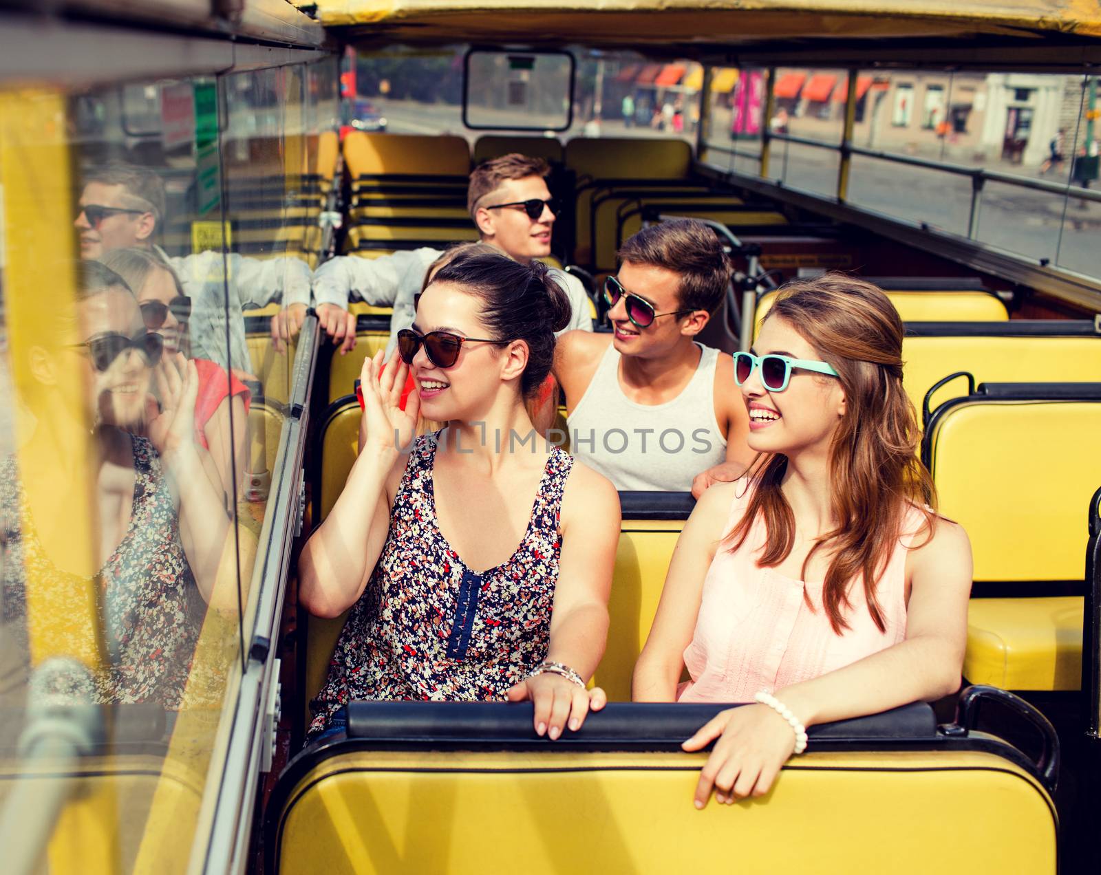 group of smiling friends traveling by tour bus by dolgachov