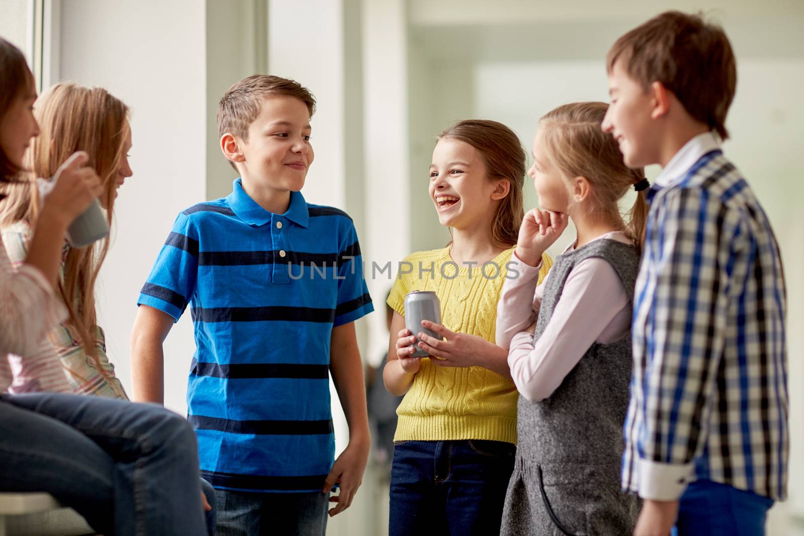 education, elementary school, drinks, children and people concept - group of school kids with soda cans talking in corridor