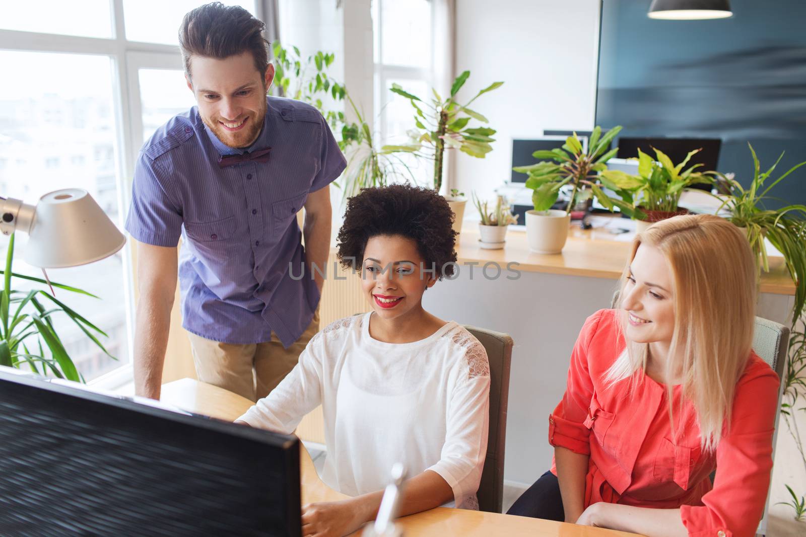 business, startup and people concept - happy creative team networking with computer in office