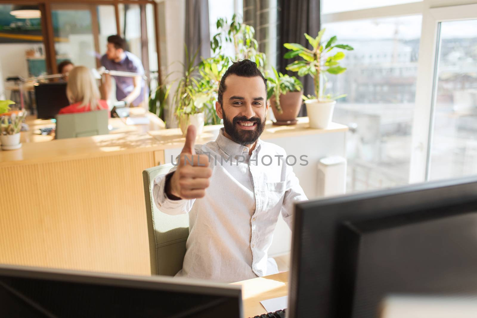 happy male office worker showing thumbs up by dolgachov