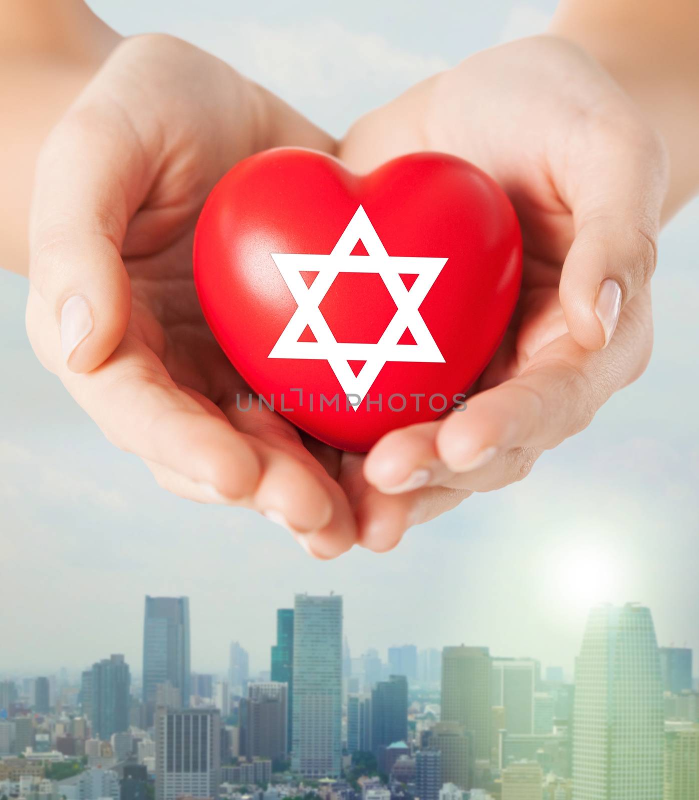 religion, christianity, jewish community and charity concept - close up of female hands holding red heart with star of david symbol over city skyscrapers background