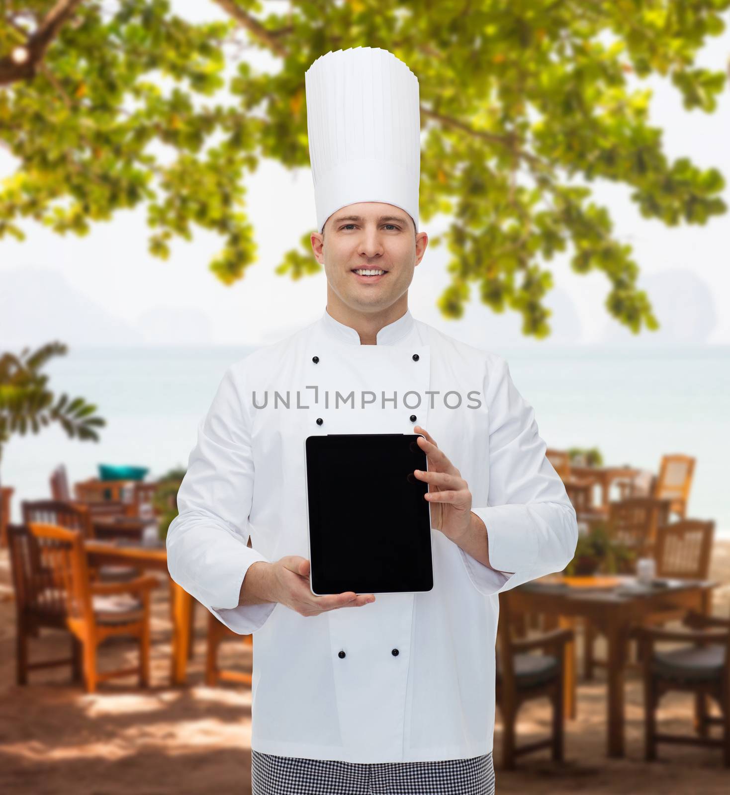 happy male chef cook showing with tablet pc by dolgachov