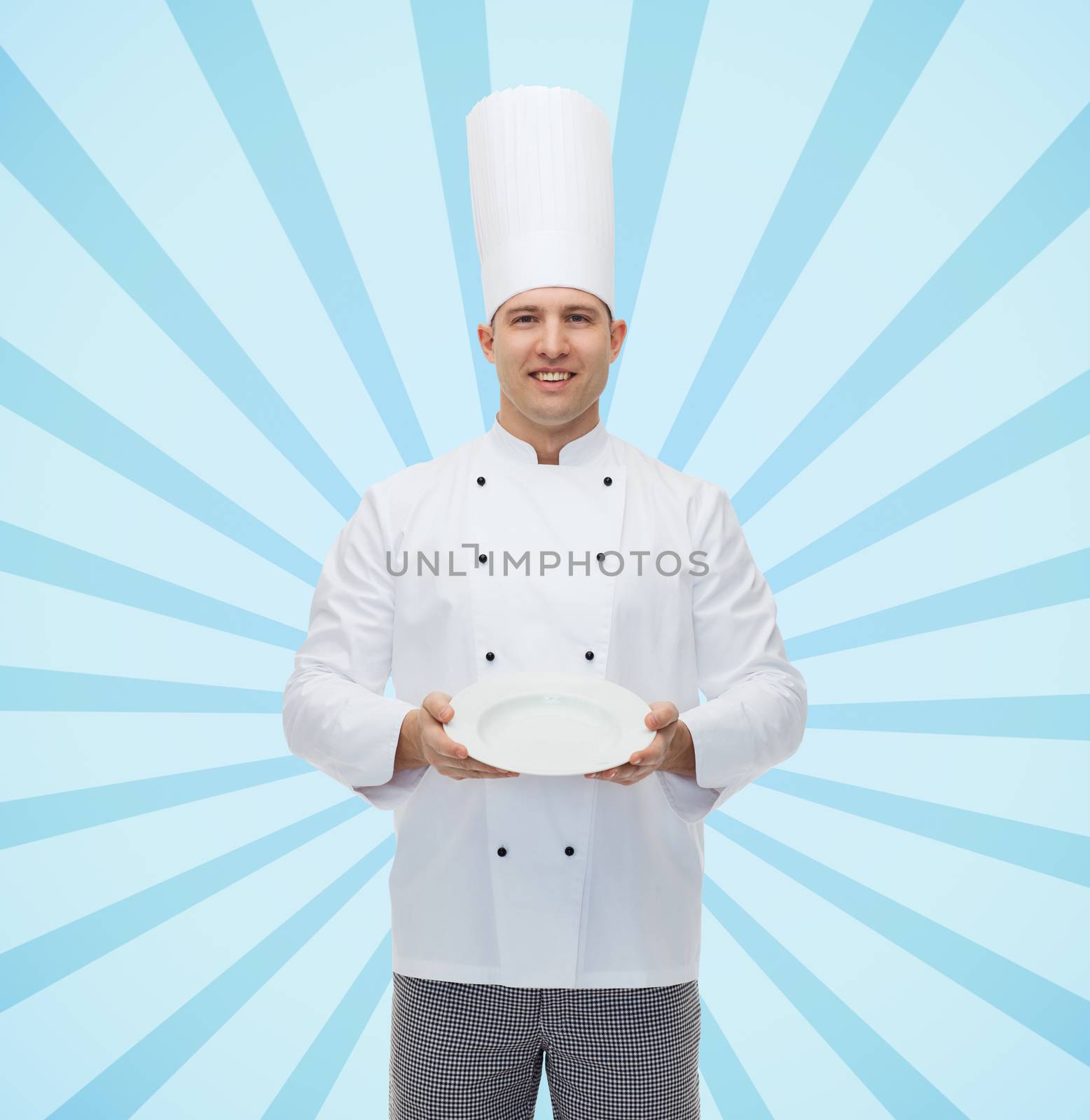 cooking, profession, advertisement and people concept - happy male chef cook showing something on empty plate over blue burst rays background