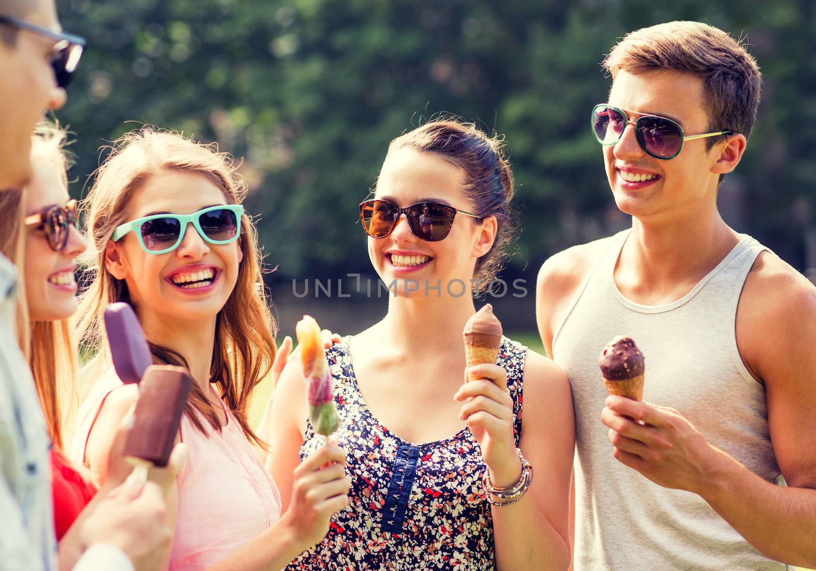 group of smiling friends with ice cream outdoors by dolgachov