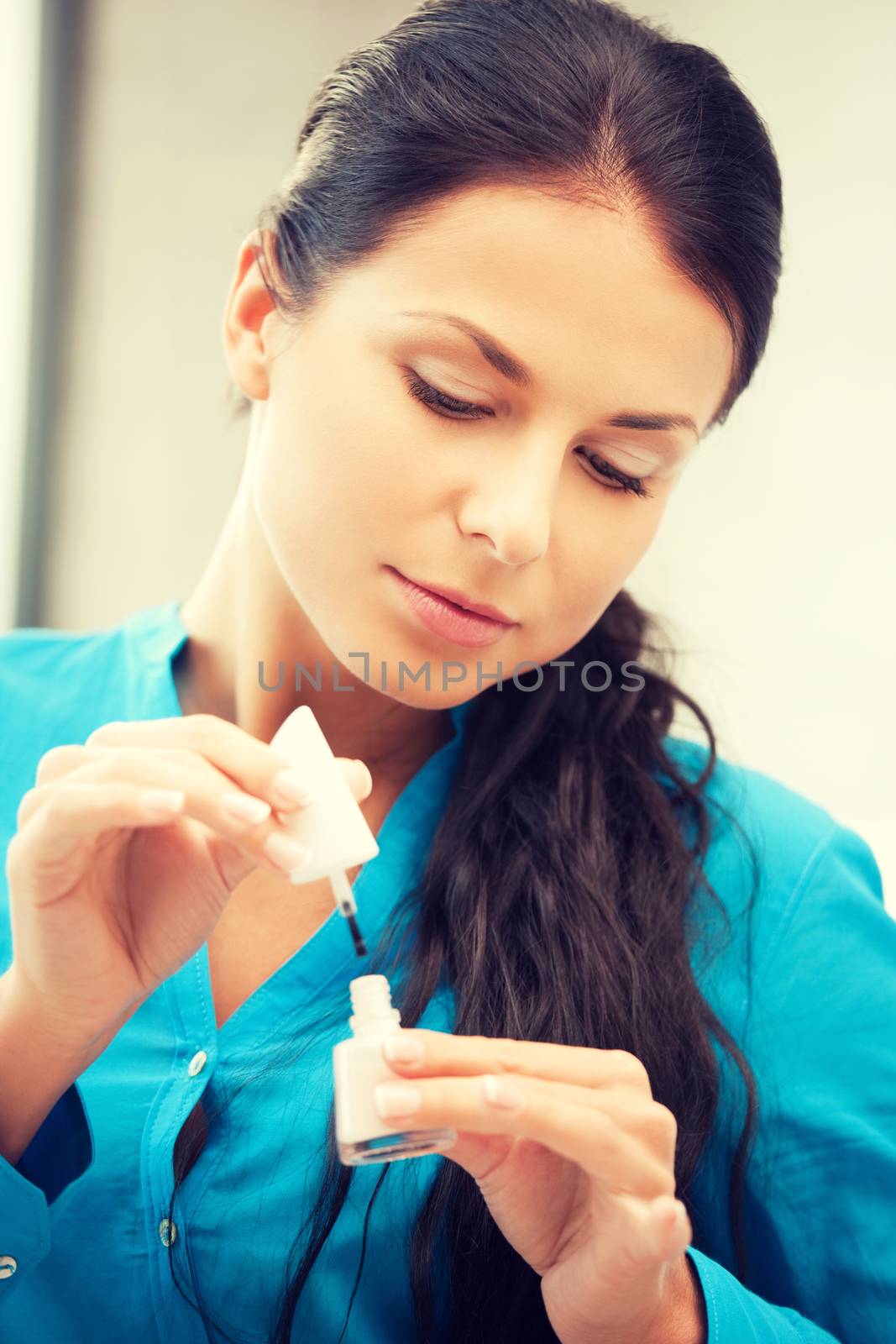 picture of beautiful woman polishing her nails