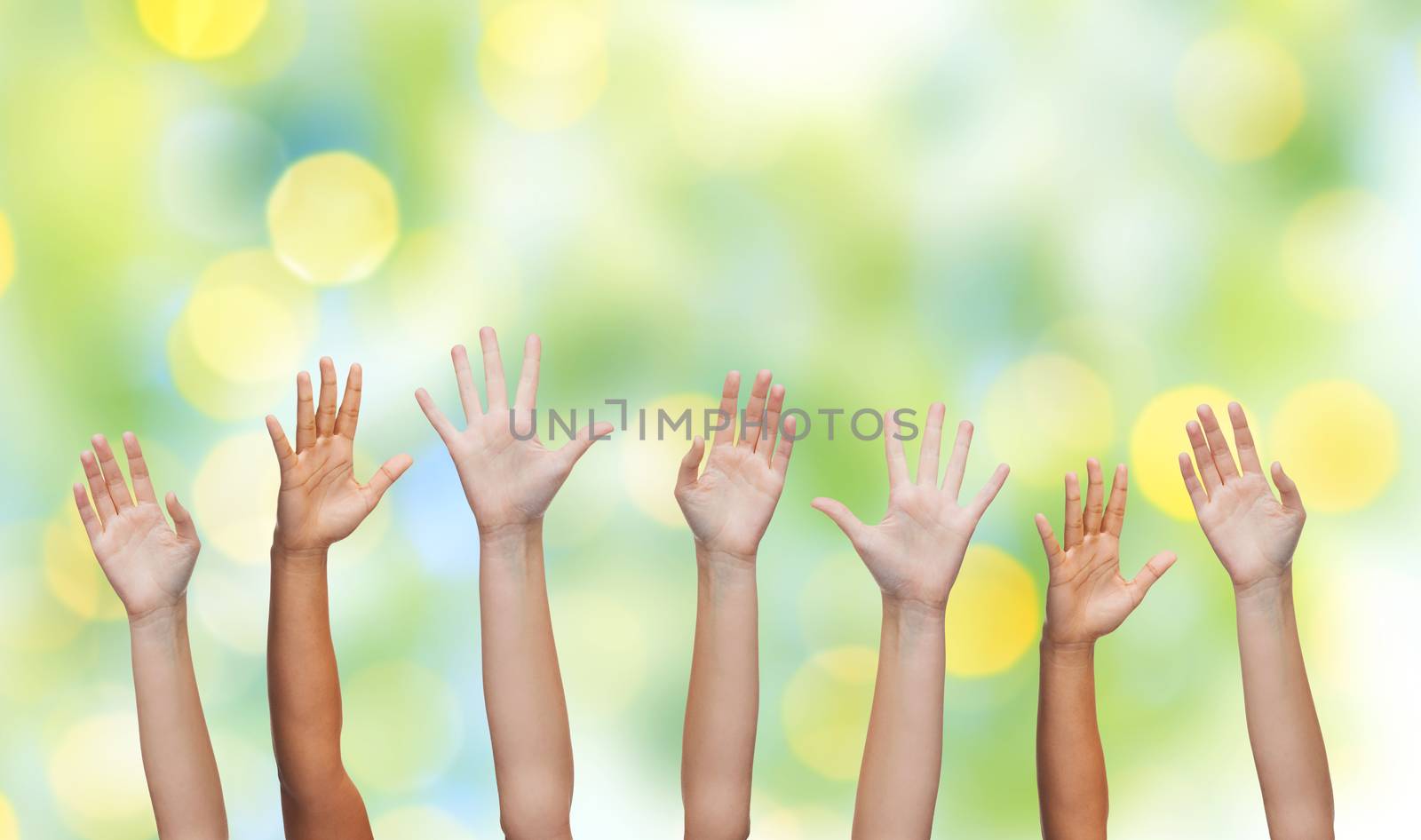 gesture, greeting, charity and body parts concept - people waving hands over green lights background