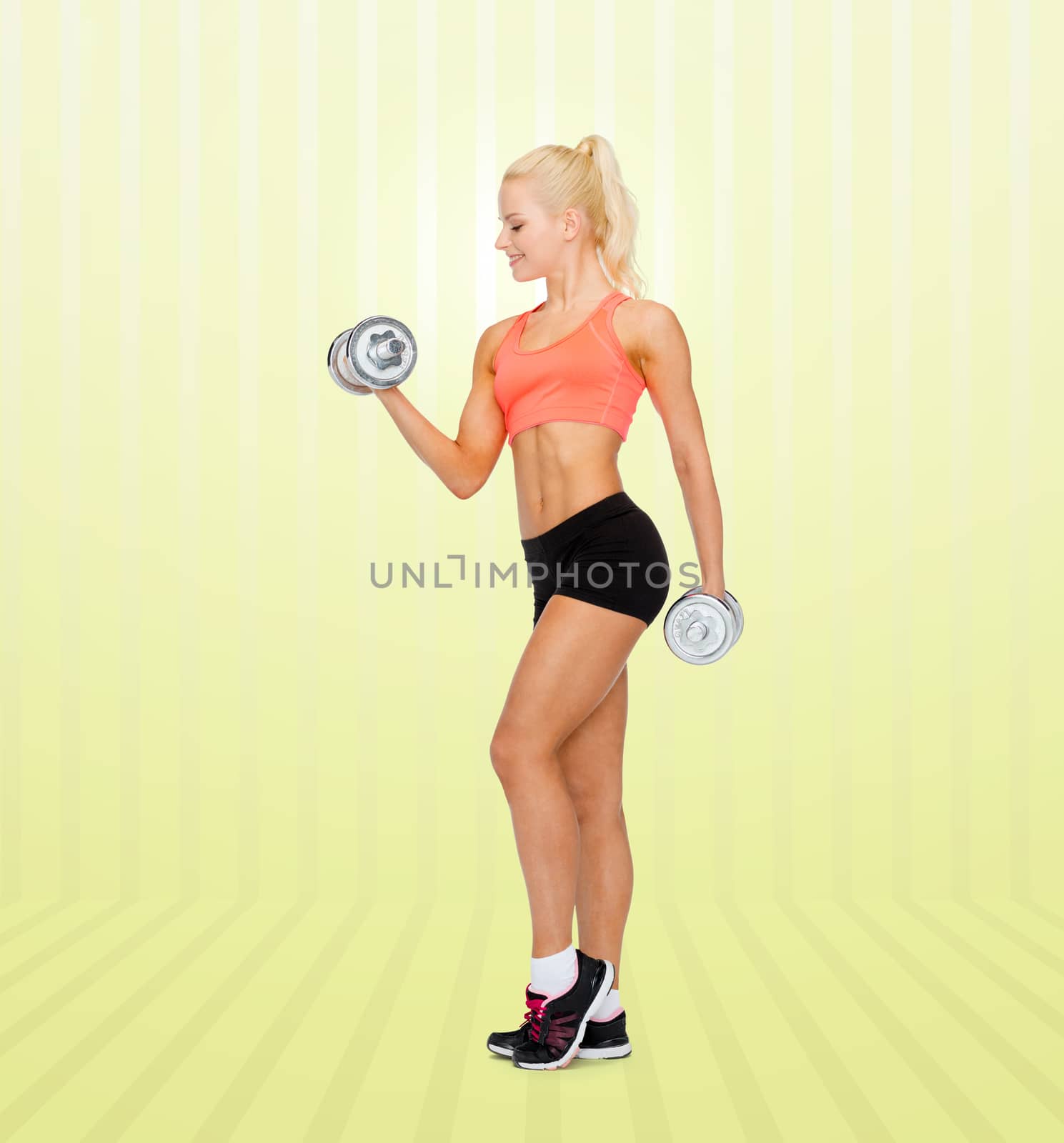 young sporty woman with dumbbells by dolgachov
