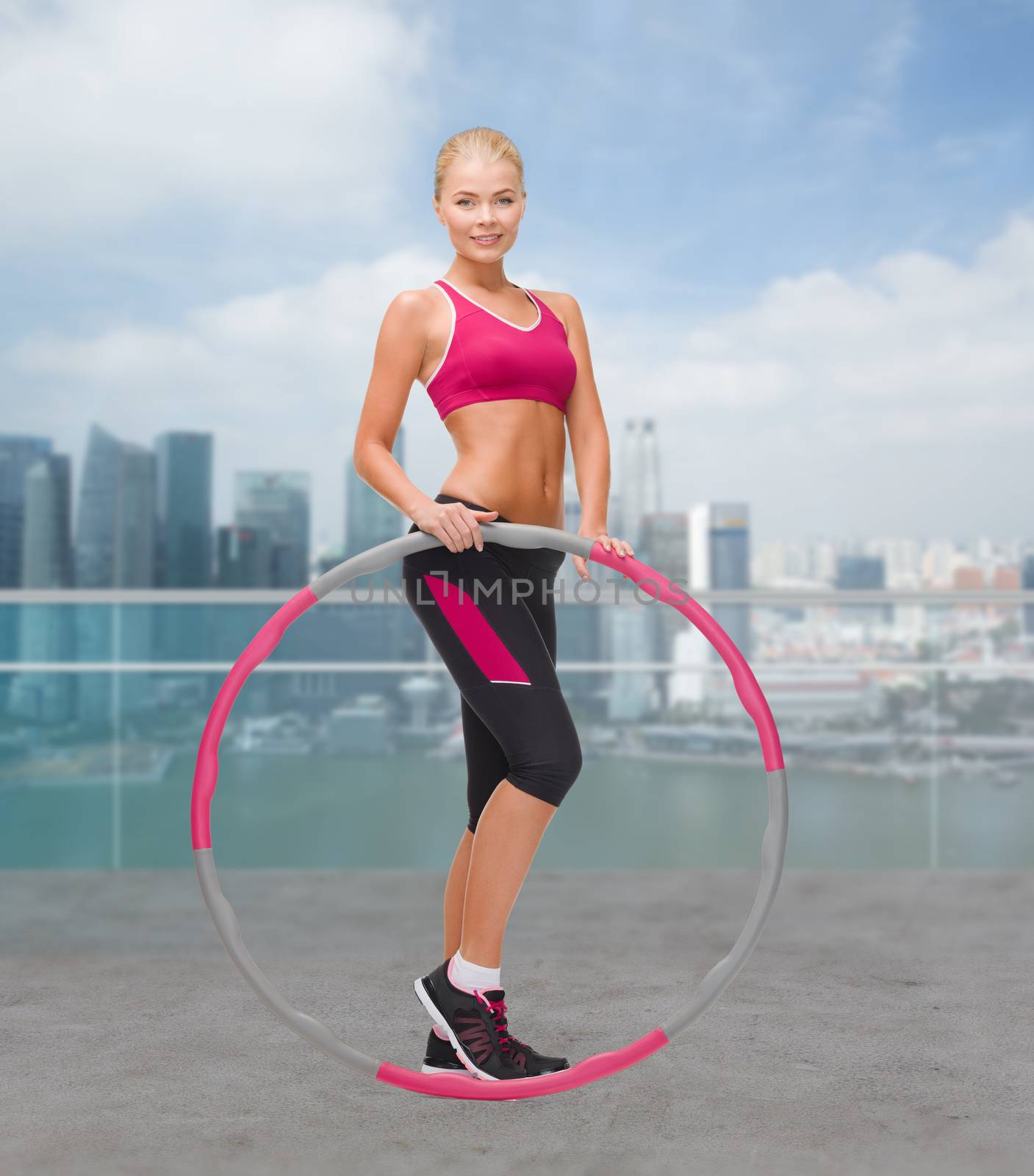 young sporty woman with hula hoop by dolgachov